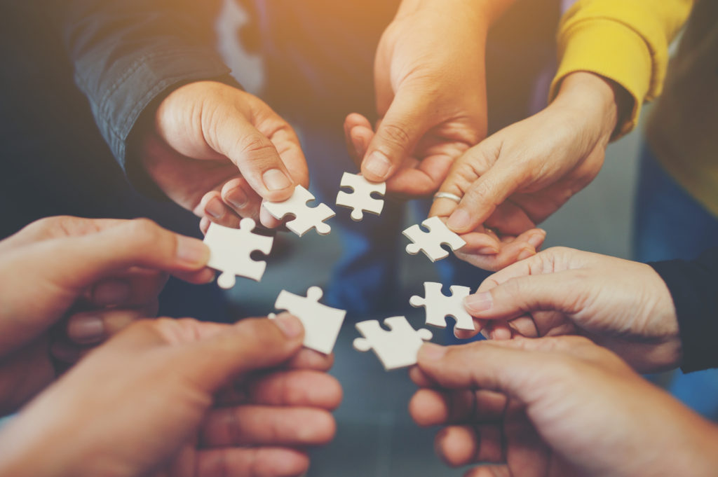 Blog Header Image - team holding puzzle pieces